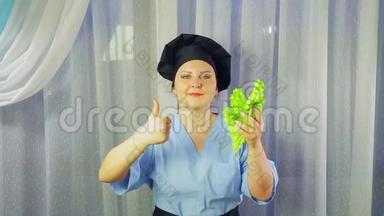 女厨师穿着围裙<strong>微</strong>笑，手拿绿色沙拉，用手展示<strong>课</strong>堂。